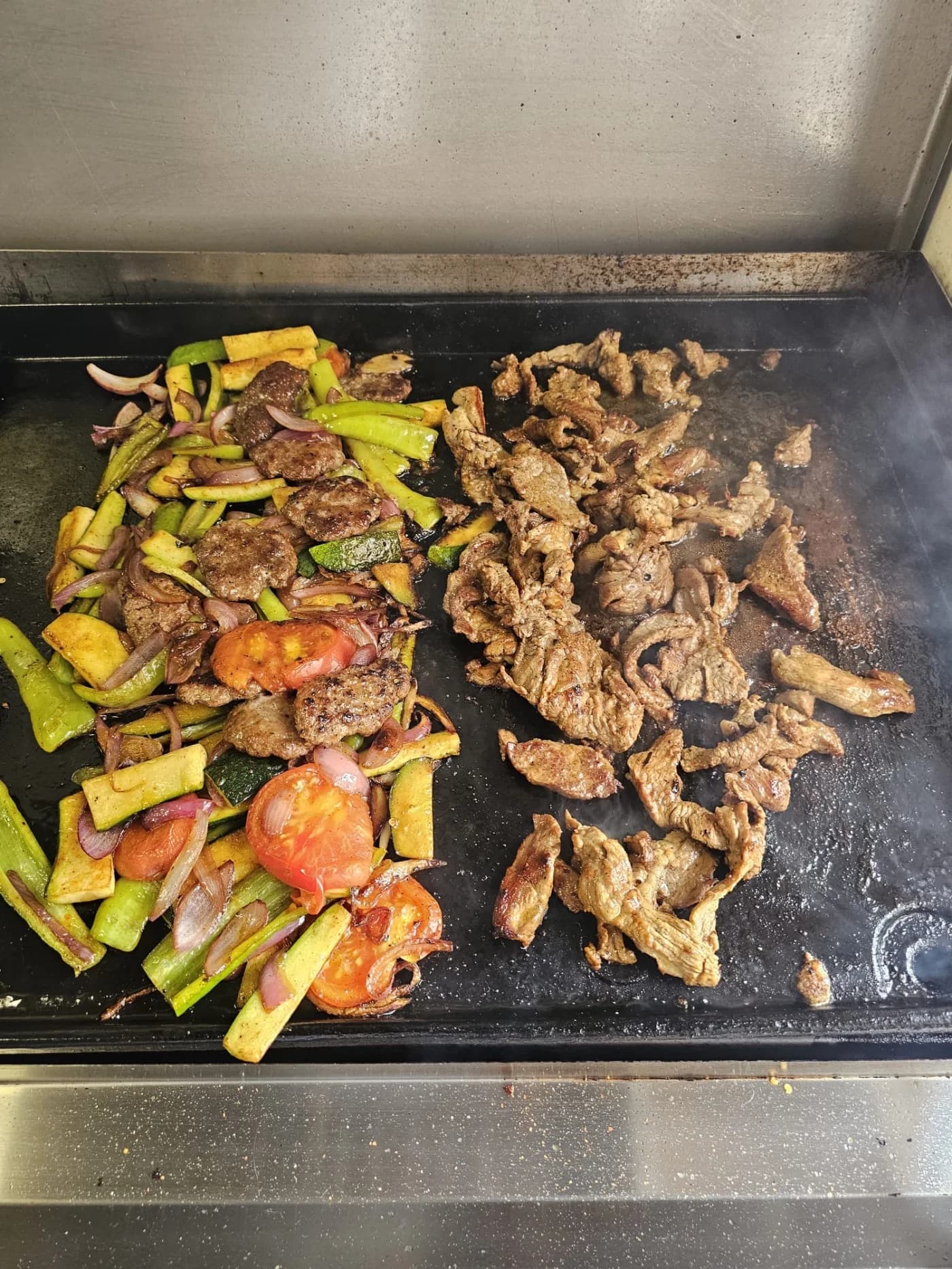 Fleisch, Köfte und Gemüse bei der Zubereitung auf dem Grill